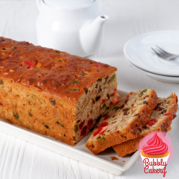 A moist fruit cake loaded with mixed fruits and nuts, sliced and served on a wooden platter.
