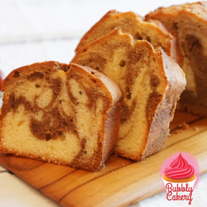 A soft marble cake showcasing swirls of chocolate and vanilla, sliced and displayed on a white tray.